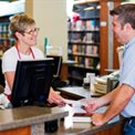 Man checking books out of a library